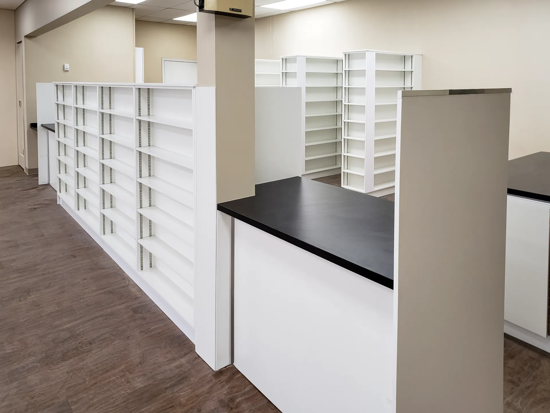 Adjustable pharmacy shelf wall in white melamine