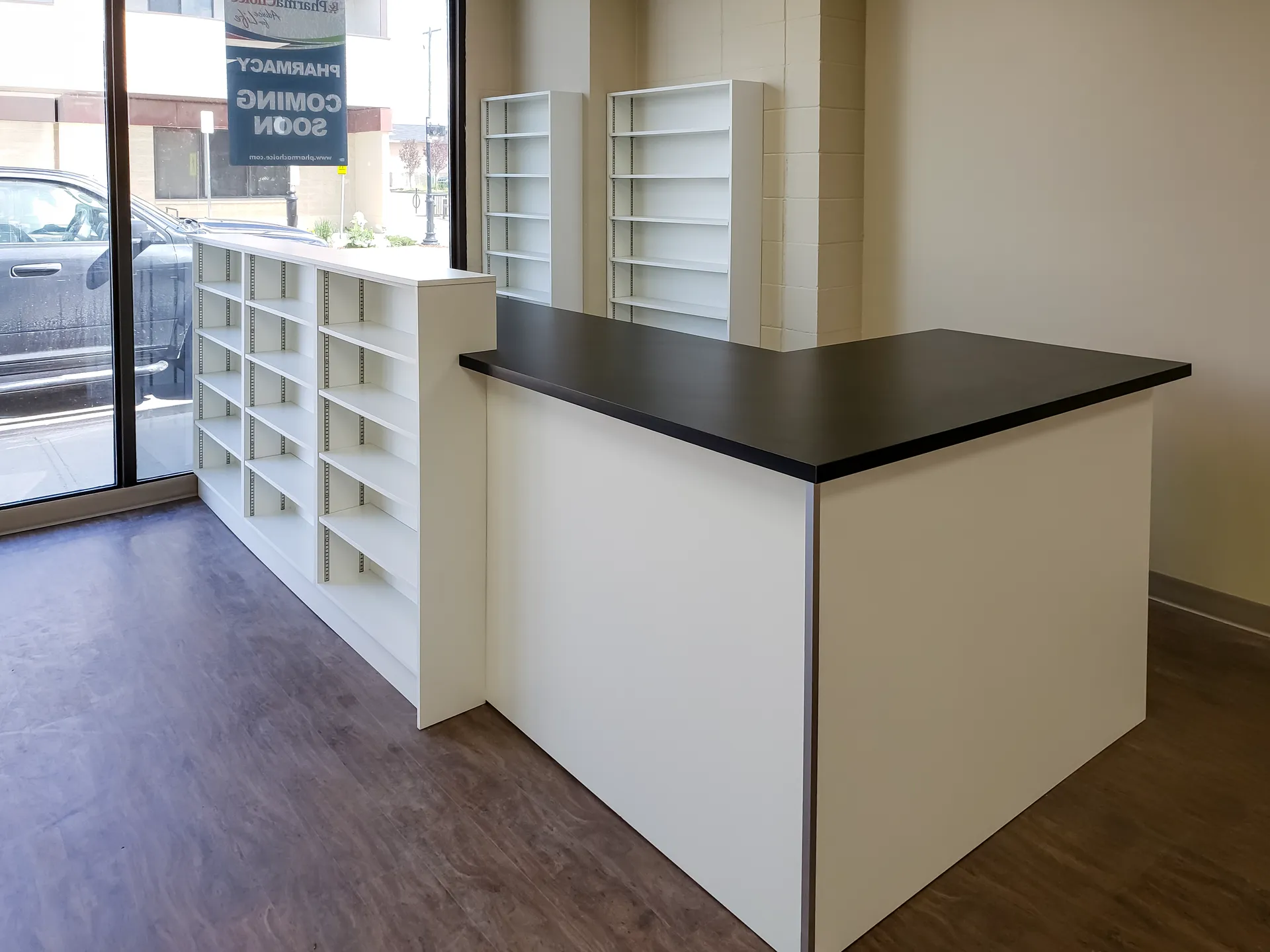 Pharmacy pickup counter and retail shelving at the front window